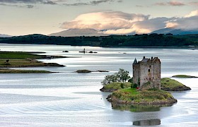 Castle Stalker with lismore in the background on Loch Linnhe with Hebrides Cruises